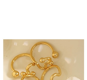 Gros plan d'un pendentif doré avec perle et billes dans un plat de style vintage