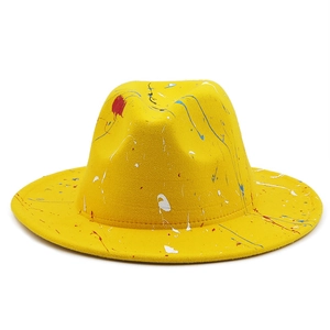 Close-up of yellow felt fedora hat featuring artistic colorful paint splatter patterns