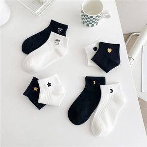 Set of 4 pairs of women's black and white cotton socks with embroidered smile, star, and moon