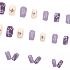 Short square press-on nails with purple floral patterns and creamy white accents