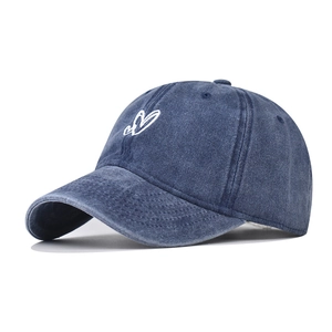 Washed vintage navy blue baseball cap featuring a white embroidered heart on the front