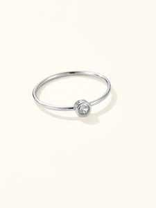 Detailed close-up of a sterling silver ring with a clear zircon stone in a bezel setting