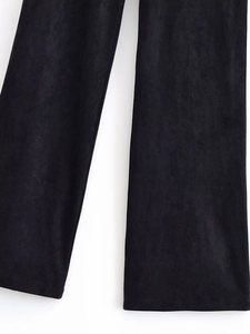 Detailed close-up of black suede flared pants showing premium fabric texture and hem