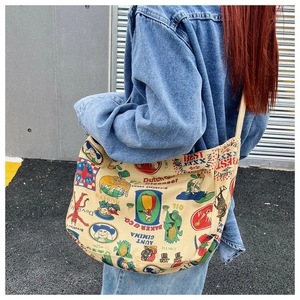 Outdoor shot of the vintage printed canvas crossbody bag shown on a model's back