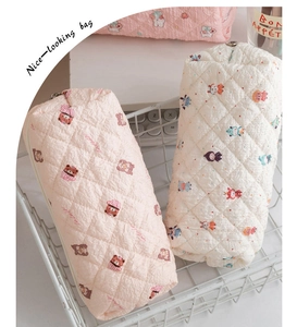 Close-up of quilted cotton pencil cases with cute bear and rabbit prints in a mesh basket