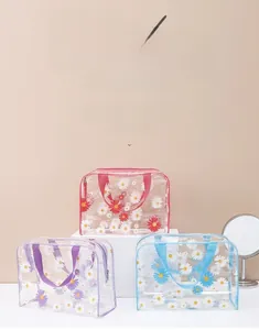 Three waterproof PVC travel wash bags with daisy patterns in pink, purple, and blue colors