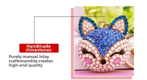 Macro detail of fox keychain with blue rhinestones and white pearls on gold metal