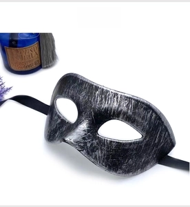 Detailed view of a vintage silver masquerade mask with metallic texture and black ribbons