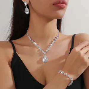 Detail of 3-piece silver jewelry set with water-drop white crystals on elegant model