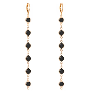Detail of long gold earrings featuring six dangling black round stones in a vertical row