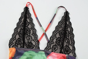 Close-up of black floral lace trim and vibrant watercolor print on a summer dress