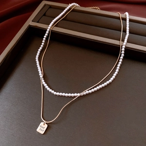 Dettaglio del ciondolo rettangolare placcato oro 14K con incisione Good Luck su velluto