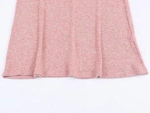 Gros plan sur la texture en maille rose et le détail de l'ourlet de cet ensemble chic