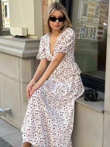 Détail d'une robe midi fleurie à col en V avec manches bouffantes et taille fluide