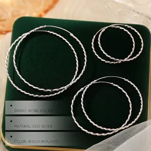 Three sizes of S925 sterling silver twisted hoop earrings on green velvet pad