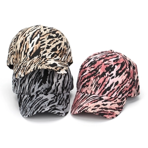 Three leopard print baseball caps in tan, grey, and pink with classic curved brims