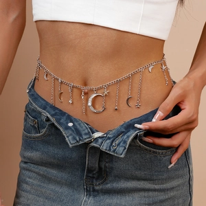 Detail of silver waist chain with moon, star charms, pearls and dangling tassels