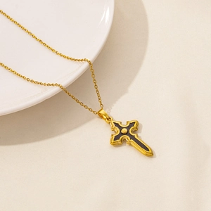 Detailed close-up of a 18K gold-plated stainless steel necklace with a black gothic cross pendant