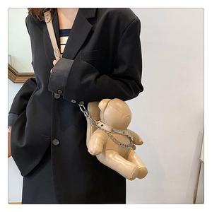 Detail of cute bear-shaped PU leather crossbody bag with silver chain on model