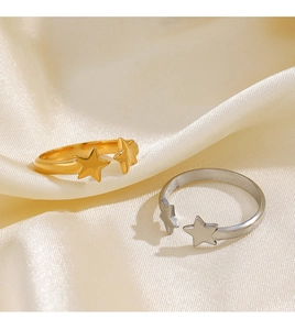 Detailed view of gold and silver adjustable star rings on soft silk fabric textures