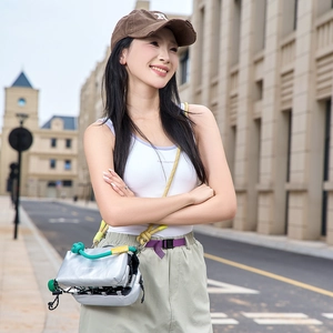 Silver outdoor crossbody bag with green rope detail shown in a street style outfit