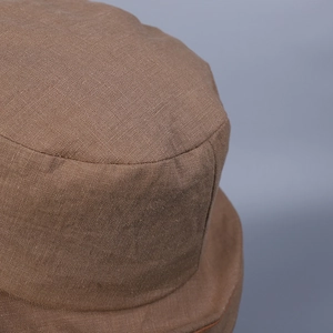 Close-up of vintage brown linen fabric and stitching on a double-brim bucket hat
