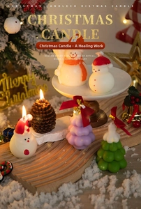 Detailed view of lit Christmas tree, snowman, and pine cone scented candles with red ribbons