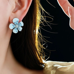 Macro detail of gradient crystal flower earring featuring sparkling core on model