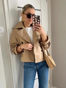 Chic khaki double-breasted short trench coat for women styled with casual denim jeans