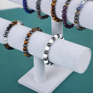 Detail of diverse stone bead bracelets displayed on a grey velvet T-bar jewelry stand