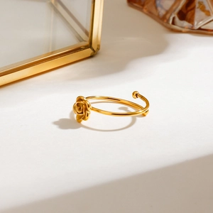 18k gold plated stainless steel rose flower open ring displayed on a minimal surface