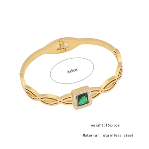 Detailed view of a gold stainless steel bangle with green stone and small diamonds