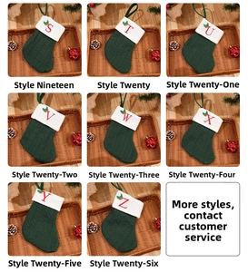 Detail of green cable knit Christmas stockings with red embroidered alphabet initials