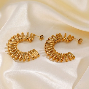 Chunky 18K gold plated C-shaped spiral hoop earrings displayed on elegant beige silk fabric