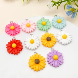 Close-up of colorful resin daisy charms with metal rings for DIY jewelry making