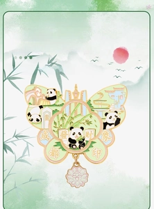 Detail of butterfly-shaped metal panda fridge magnet with enamel finish and floral pendant