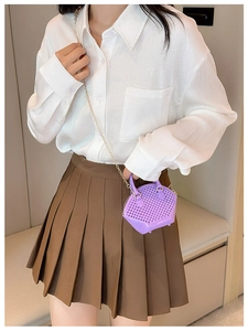 Detail view of purple mini shell bag featuring woven texture and gold chain strap