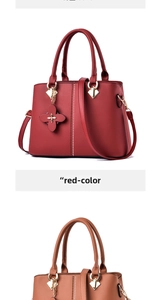 Detailed macro view of red leather tote bag with clover charm and gold hardware