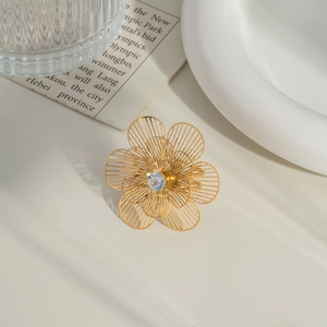 Detailed view of hollow camellia flower ring with center zircon on a gold band
