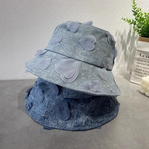 Detailed texture of denim bucket hats with 3D heart embroidery and stone wash finish