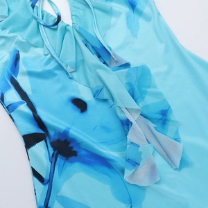 Détail du décolleté en V avec volants et imprimé floral bleu sur tissu léger