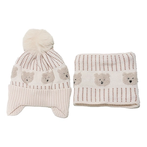 Detail of winter knit hat and neck warmer set with cute bear pattern and pom-pom