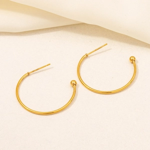 Detailed view of polished 18K gold-plated C-shaped hoop earrings with decorative beads
