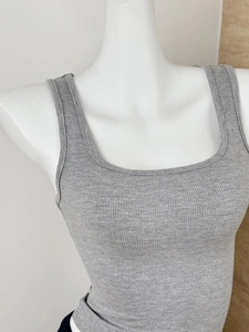 Détail de la texture en maille côtelée grise et de l'encolure carrée du débardeur de fitness