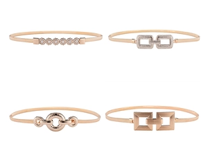 Vue détaillée de quatre ceintures à ressort en métal or rose avec boucles à fleurs en strass