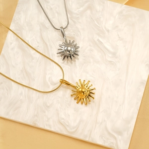 Minimalist 18k gold and silver sun pendant necklaces with sleek snake chains on marble