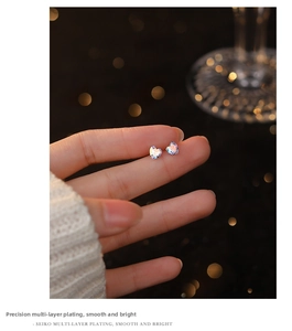 Macro shot of heart-shaped aurora stud earrings with vibrant iridescent crystal detail