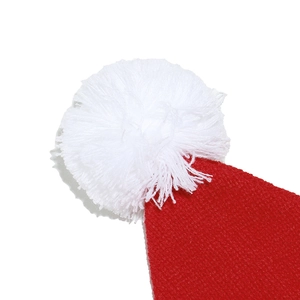 Close-up of a festive red knit Santa hat featuring a fluffy white faux fur pom-pom detail