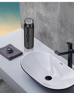 Portable mini electric shaver for men in a modern bathroom setting with non-slip texture