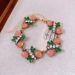 Vintage floral bracelet with pink oval stones, green leaf gems, and sparkling crystals